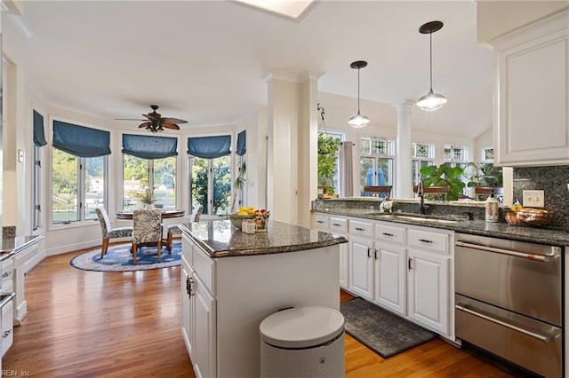 kitchen with white cabinets, stainless steel dishwasher, and wood finished floors