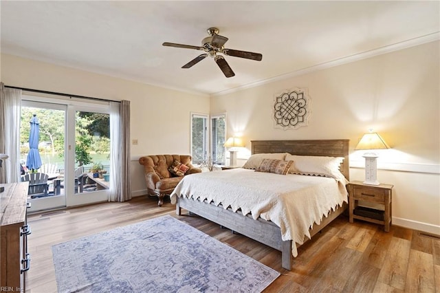 bedroom featuring baseboards, ornamental molding, wood finished floors, and access to exterior