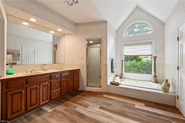 full bathroom featuring a garden tub, wood finished floors, vaulted ceiling, a stall shower, and wallpapered walls