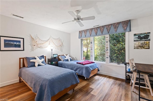 bedroom with visible vents, baseboards, and wood finished floors