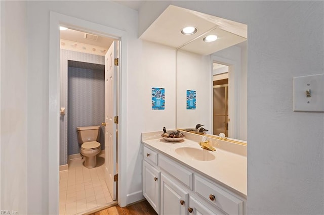 bathroom with baseboards, visible vents, toilet, a shower with shower door, and vanity