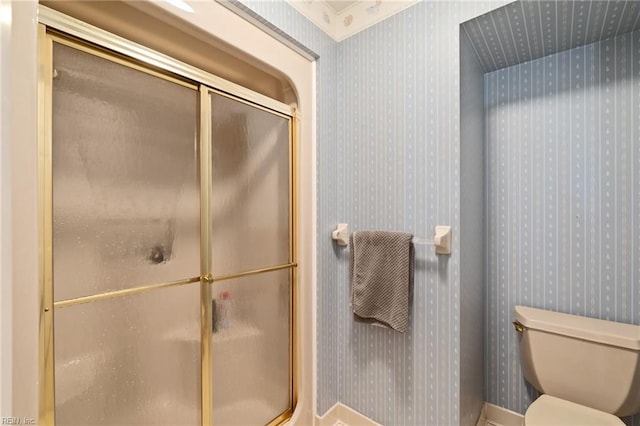 full bathroom featuring toilet, wallpapered walls, and a shower stall