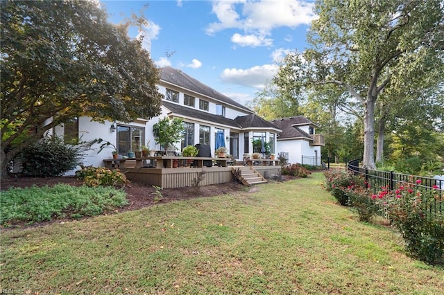 rear view of house featuring a fenced backyard, a lawn, and a wooden deck