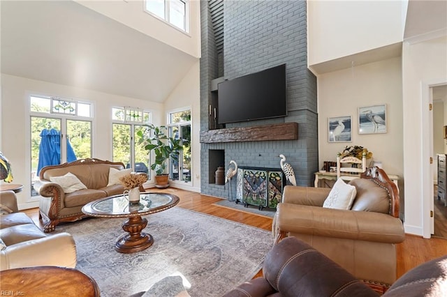 living room with baseboards, a fireplace, a high ceiling, and wood finished floors