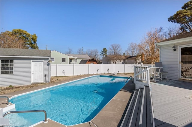 view of swimming pool with a fenced backyard, a diving board, a fenced in pool, and a wooden deck