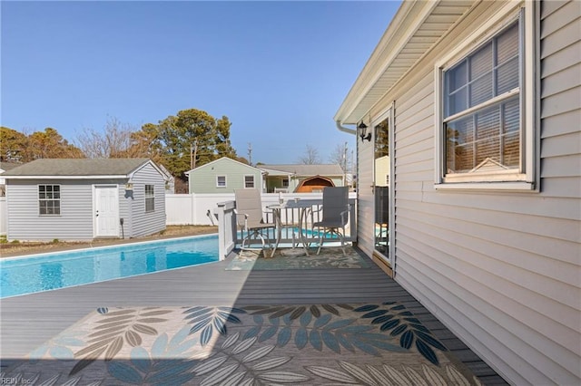 view of pool with a deck, an outbuilding, fence, a fenced in pool, and outdoor dining space