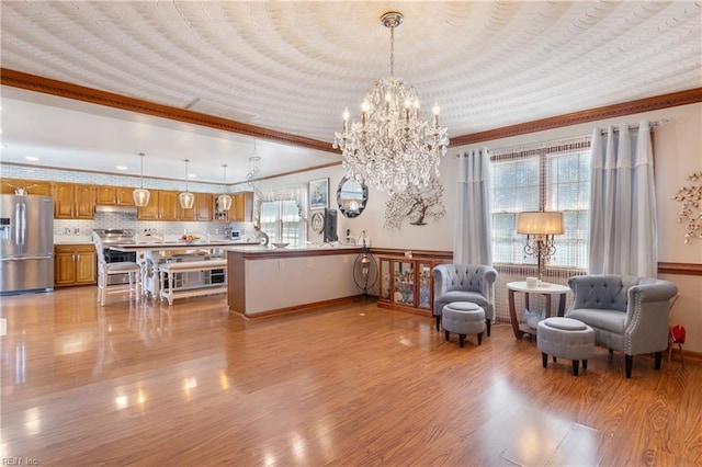 sitting room featuring light wood-style flooring, ornamental molding, and baseboards