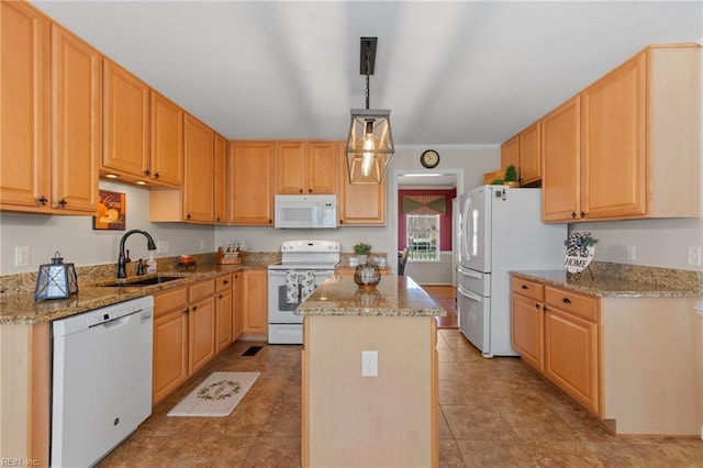 kitchen featuring light stone counters, a center island, hanging light fixtures, a sink, and white appliances