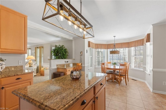 kitchen featuring a center island, visible vents, crown molding, and light tile patterned floors