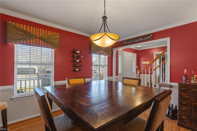 dining space with stairway, baseboards, ornamental molding, and wood finished floors