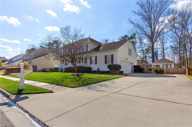 view of front facade featuring a garage, driveway, a front yard, and fence