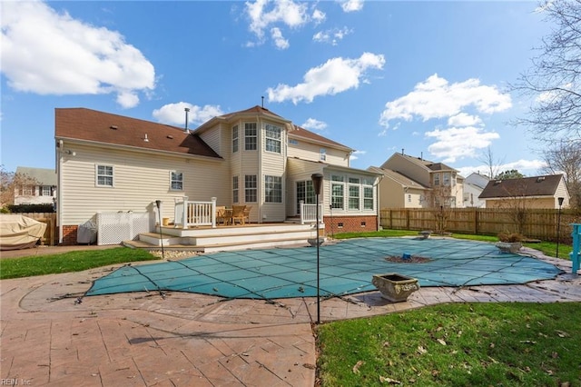 back of house featuring a wooden deck, crawl space, fence, and a fenced in pool