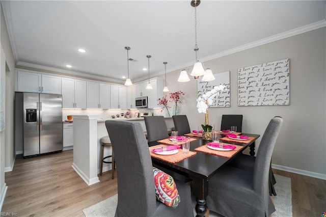 dining area featuring baseboards, light wood finished floors, recessed lighting, and crown molding