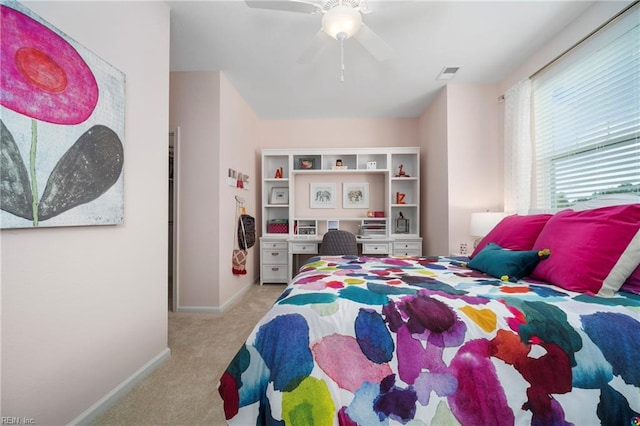 carpeted bedroom featuring a ceiling fan, visible vents, and baseboards