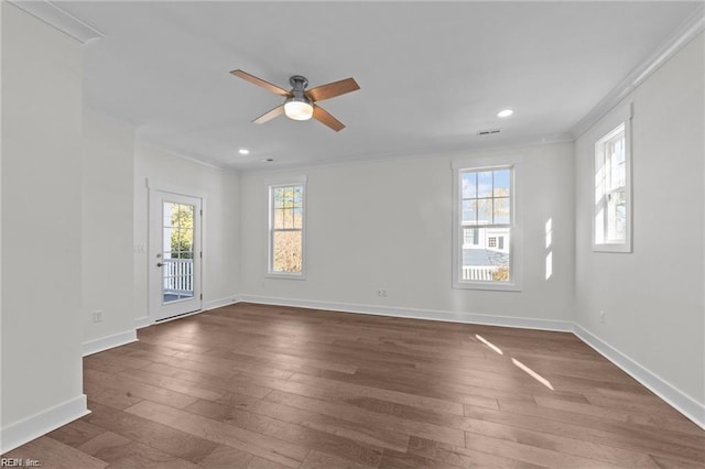 unfurnished room featuring a healthy amount of sunlight, dark wood-style floors, baseboards, and ornamental molding