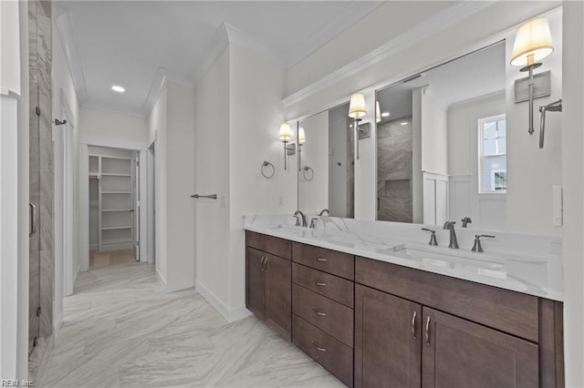 bathroom with ornamental molding, a shower with door, a sink, and a spacious closet