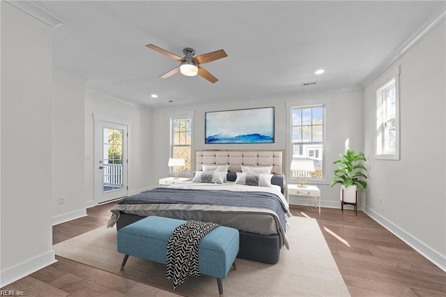 bedroom featuring multiple windows, wood finished floors, visible vents, and access to exterior