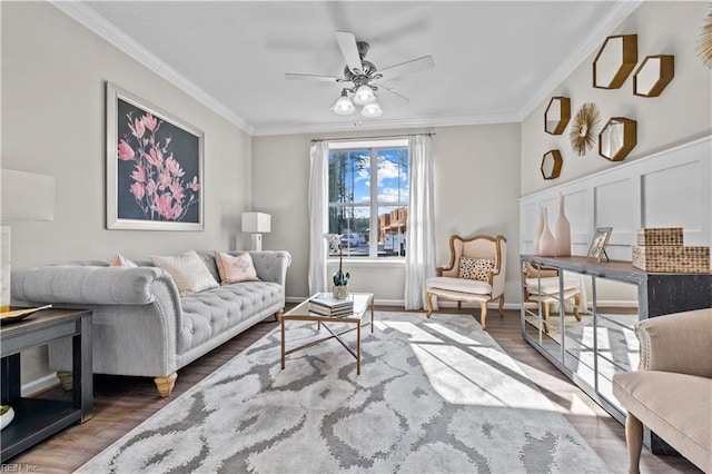 living area with wood finished floors, a ceiling fan, and crown molding