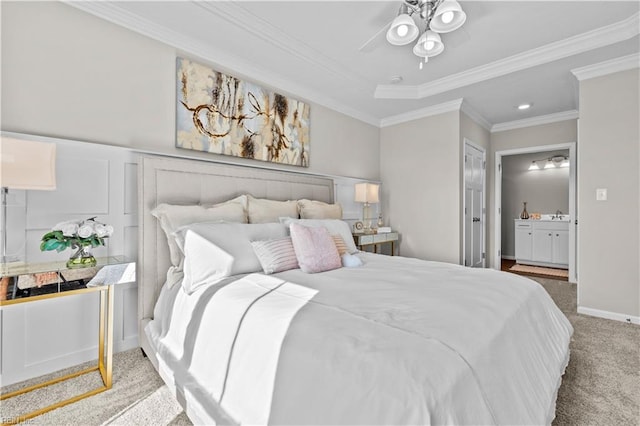 bedroom with a wainscoted wall, a decorative wall, ornamental molding, carpet flooring, and connected bathroom