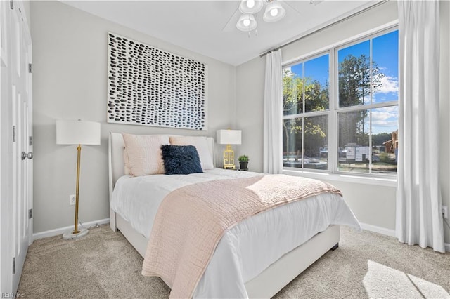 carpeted bedroom featuring multiple windows and baseboards