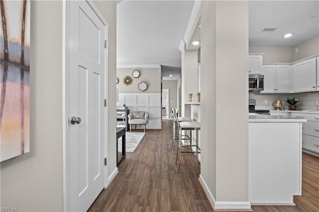 hall featuring baseboards, visible vents, dark wood-style flooring, and recessed lighting