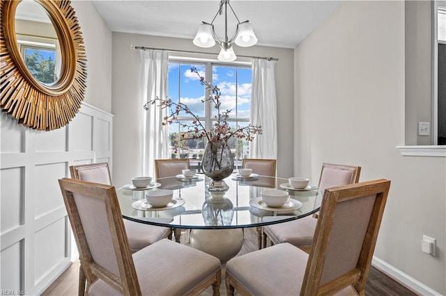 dining room featuring light wood-style flooring, baseboards, and a notable chandelier