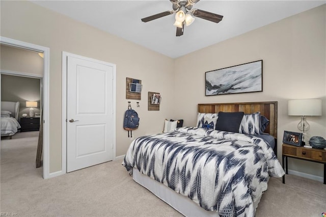 bedroom with ceiling fan, baseboards, and light colored carpet