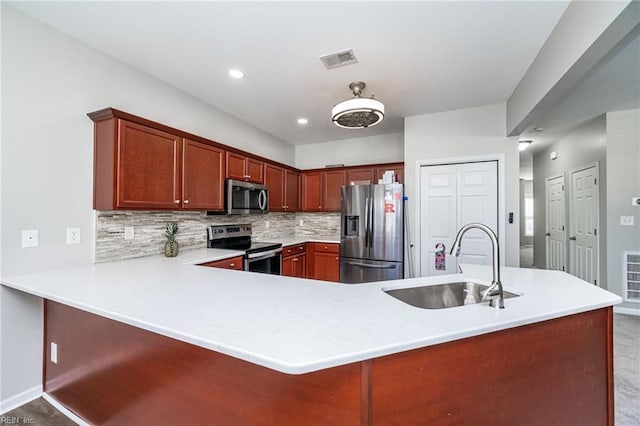 kitchen with tasteful backsplash, visible vents, stainless steel appliances, light countertops, and a sink