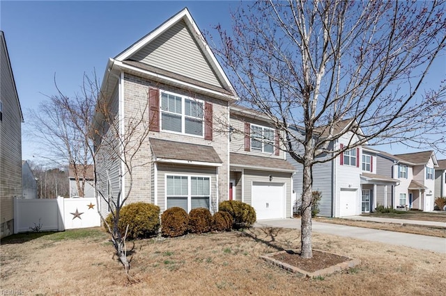 view of front facade with driveway, an attached garage, and fence