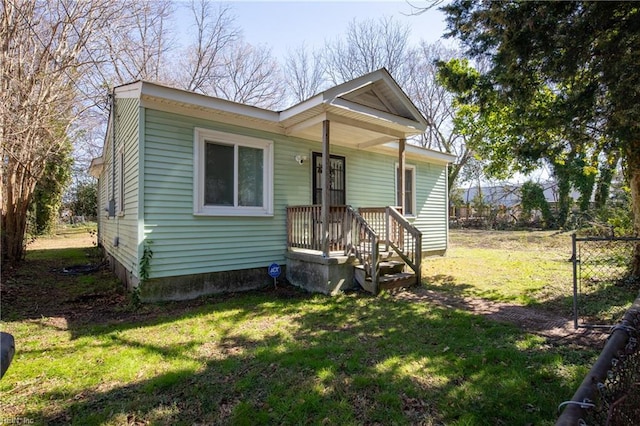 bungalow-style house with fence and a front lawn