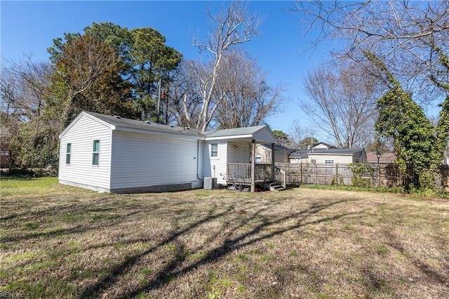 back of property featuring fence and a yard