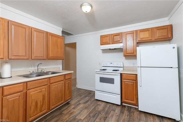 kitchen featuring dark wood-style flooring, visible vents, a sink, white appliances, and under cabinet range hood