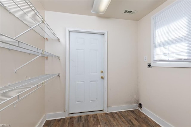 interior space featuring visible vents, hookup for an electric dryer, wood finished floors, laundry area, and baseboards