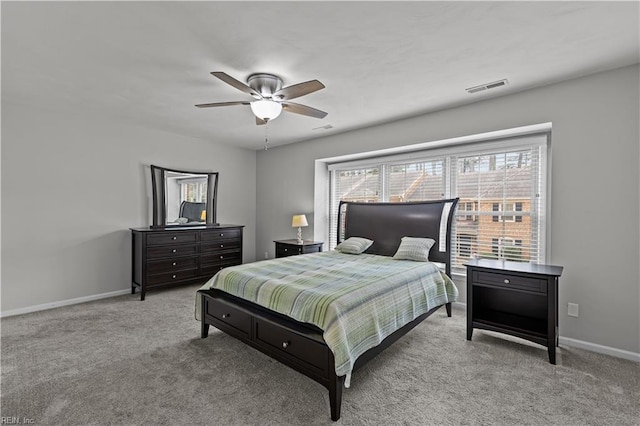 carpeted bedroom featuring a ceiling fan, visible vents, and baseboards