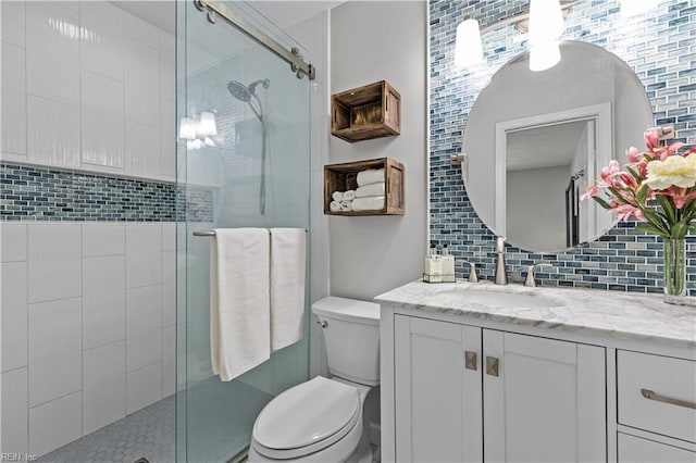 full bath featuring toilet, a stall shower, backsplash, and vanity