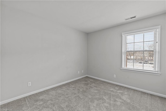 empty room featuring baseboards, visible vents, and carpet flooring