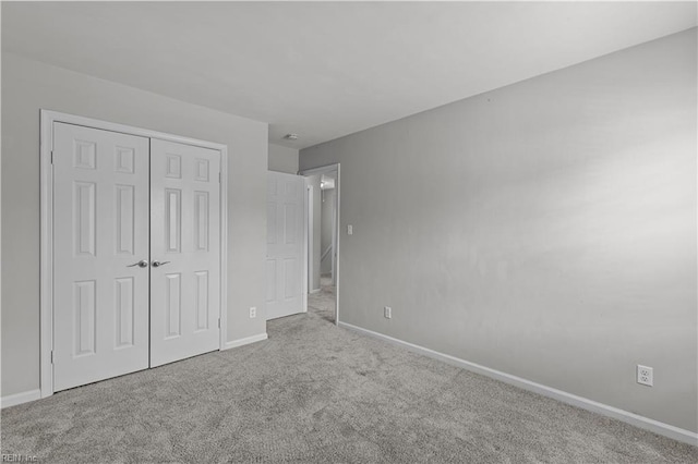 unfurnished bedroom featuring a closet, baseboards, and carpet flooring