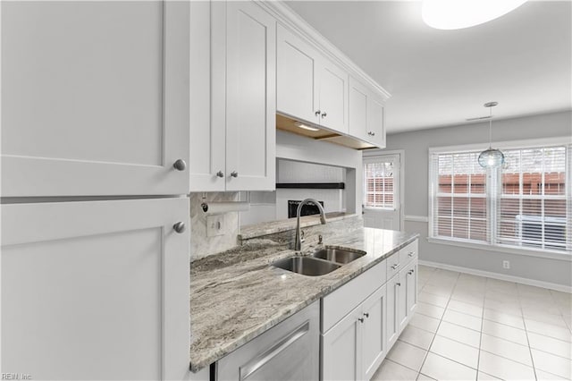 kitchen with light tile patterned floors, plenty of natural light, white cabinetry, and a sink