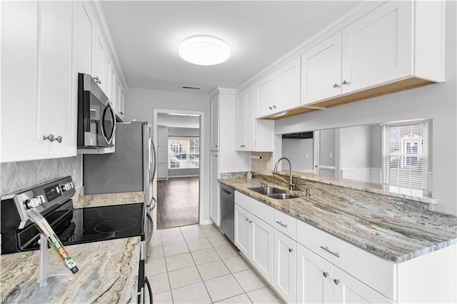 kitchen featuring light tile patterned floors, white cabinetry, stainless steel appliances, and a sink