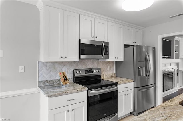 kitchen featuring stainless steel appliances, tasteful backsplash, visible vents, and white cabinets