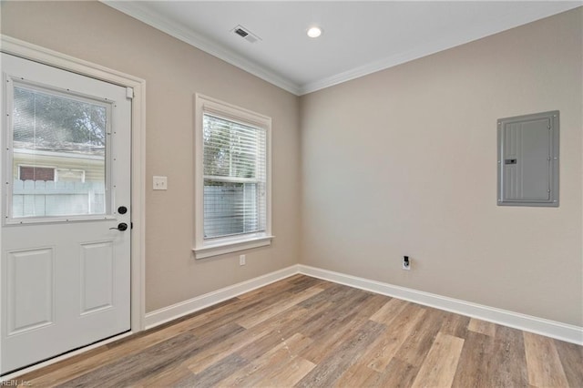 interior space featuring ornamental molding, electric panel, visible vents, and baseboards