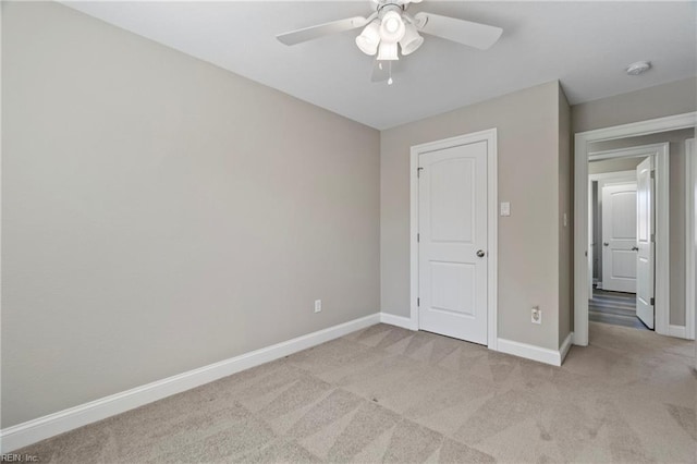 unfurnished bedroom with light carpet, ceiling fan, and baseboards