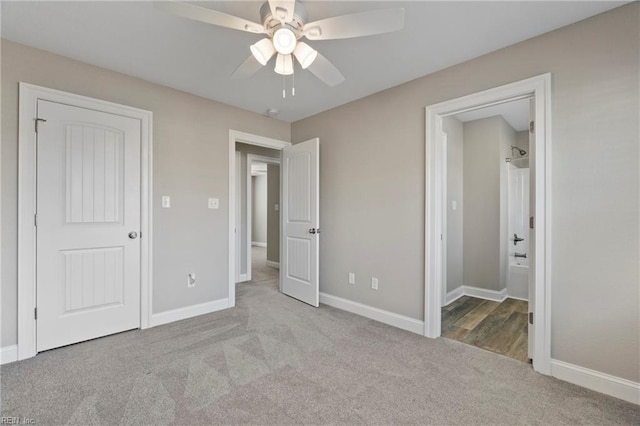 unfurnished bedroom featuring carpet floors, baseboards, a ceiling fan, and ensuite bathroom