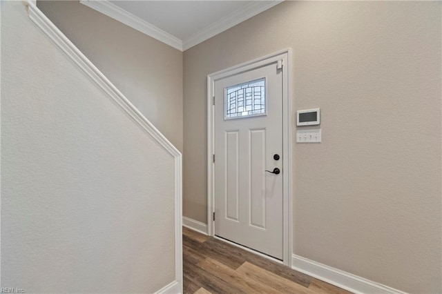 entryway featuring ornamental molding, wood finished floors, and baseboards