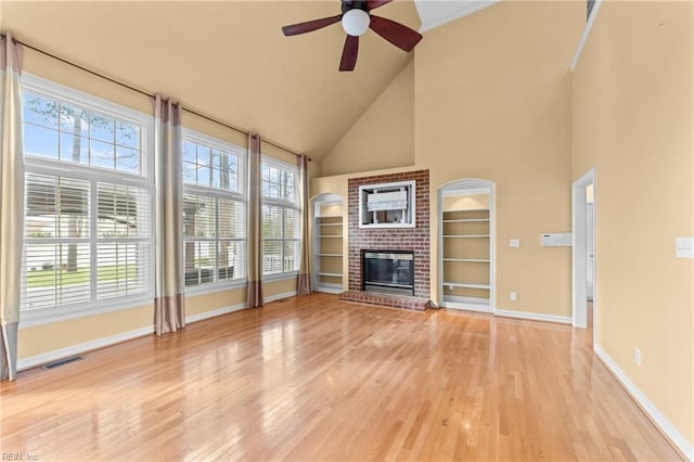 unfurnished living room featuring light wood finished floors, a fireplace, visible vents, and baseboards