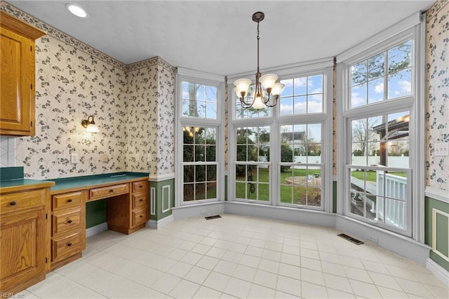 sunroom / solarium featuring visible vents and an inviting chandelier