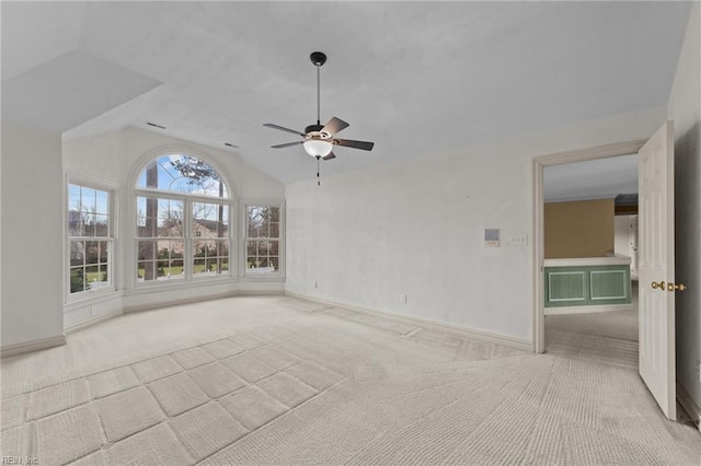 unfurnished room with light carpet, ceiling fan, lofted ceiling, and baseboards