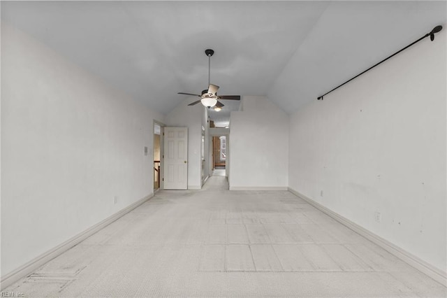 unfurnished room featuring a ceiling fan, lofted ceiling, and baseboards