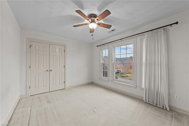 unfurnished bedroom featuring carpet floors, a closet, visible vents, and baseboards