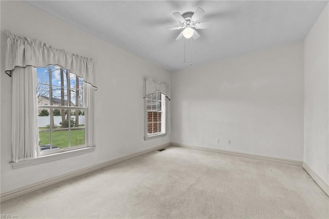 spare room with carpet floors, baseboards, and a ceiling fan